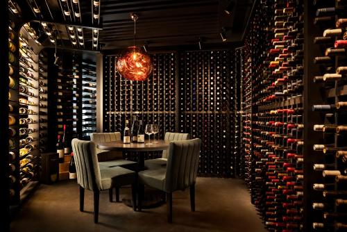 a dining room with a table and a bunch of wine bottles at Humaniti Hotel Montreal, Autograph Collection in Montréal