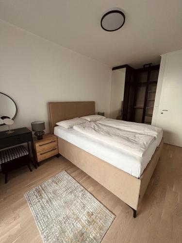 Luxury Apartment Kadic في سراييفو: غرفة نوم بسرير وطاولة وسجادة