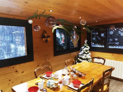 un comedor con una mesa y un árbol de Navidad en Les marmottes d Estenc, en Estenc