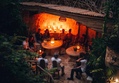 a group of people sitting at tables in a restaurant at Kan Tulum Hotel in Tulum