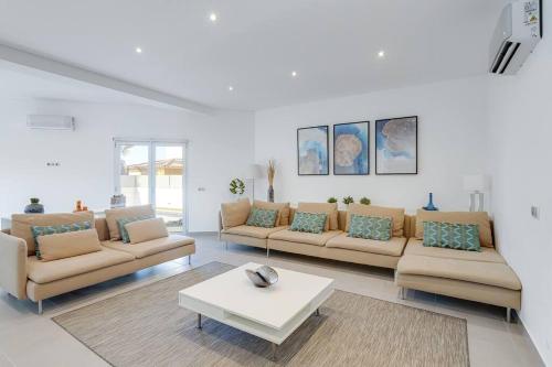 a living room with couches and a coffee table at VILLA LIMOEIRO - Beautiful new home nestled in the heart of Galé in Guia