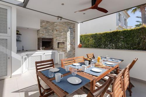 a dining room with a table and chairs and a kitchen at VILLA LIMOEIRO - Beautiful new home nestled in the heart of Galé in Guia