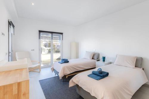 two beds in a room with blue towels on them at VILLA LIMOEIRO - Beautiful new home nestled in the heart of Galé in Guia