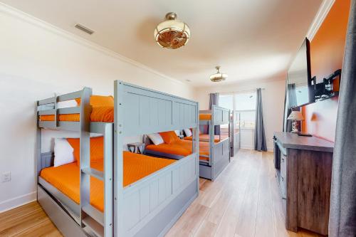 a room with three bunk beds and a desk at SunKissed in Dauphin Island