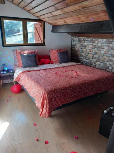 une chambre avec un grand lit avec une couette rouge dans l'établissement Palais des Rêves, à Niort