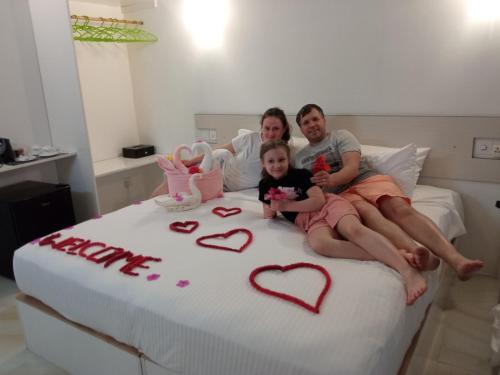 a family sitting on a bed with a birthday cake at Thoddoo Garden inn in Thoddoo