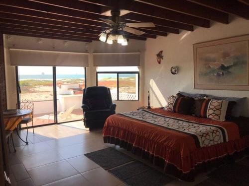 - une chambre avec un lit, une chaise et un balcon dans l'établissement Casa Safari frente a la playa, à Ensenada