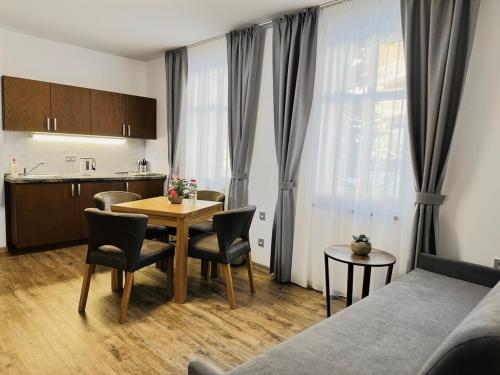 a living room with a table and chairs and a kitchen at SYNEK Pension in Špindlerův Mlýn