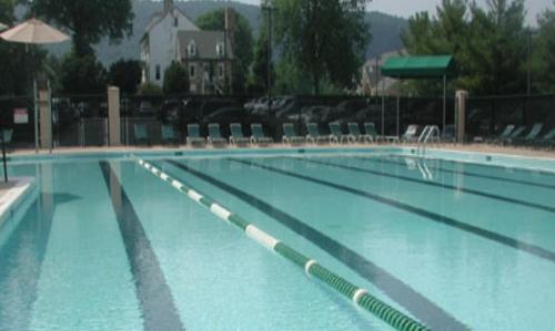 a large swimming pool with blue water and chairs at Inn at Evergreen in Haymarket