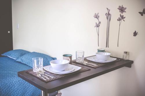 uma mesa com dois pratos e chávenas numa cama em Hermosos apartaestudios con WIFI em Bogotá