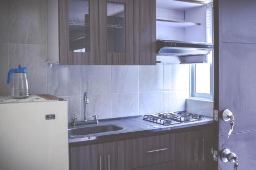 a kitchen with a sink and a stove top oven at Hermosos apartaestudios con WIFI in Bogotá