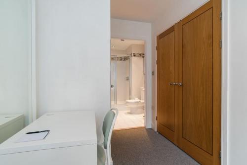 a room with a table and a bathroom with a toilet at Cardiff City Centre Apartment in Cardiff