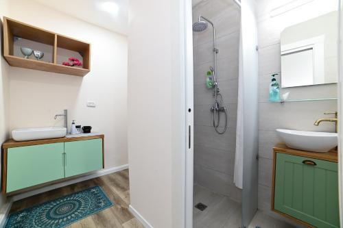 y baño con lavabo y ducha. en The Turquoise House, en Poriyya