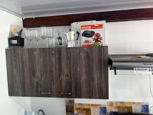 a wooden cabinet in a kitchen with glasses on it at Cabaña confortable y familiar in Coveñas