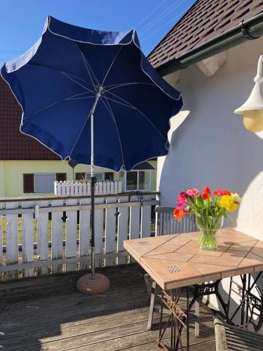 a table with a blue umbrella on a deck at Superschöne Ferienwohnungen! in Buxheim