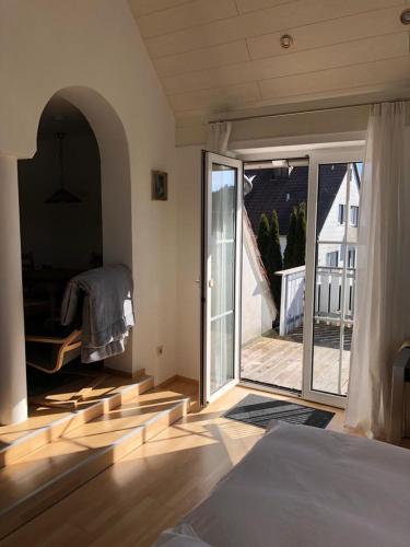 a bedroom with an open door to a balcony at Superschöne Ferienwohnungen! in Buxheim