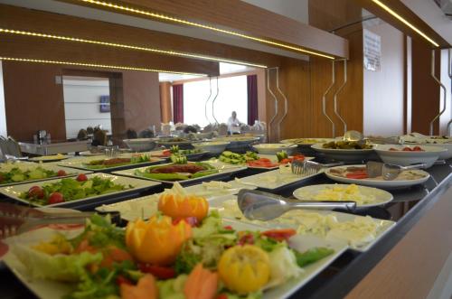 uma linha de buffet com muitos pratos de comida em Quars Garden Hotel em Koçyazı