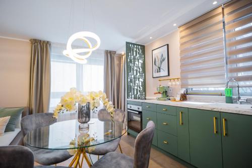 a kitchen with a glass table and some chairs at Victoriei Emerald & Pink Gems - Designer Apartments in Bucharest