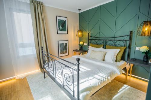 a bedroom with a bed with a green wall at Victoriei Emerald Gem - Designer Apartment in Bucharest