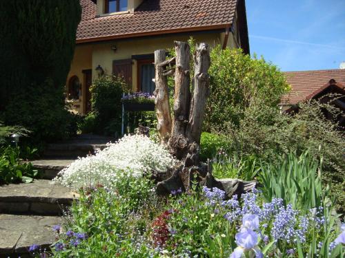 un giardino fiorito di fronte a una casa di Les Corneilles 