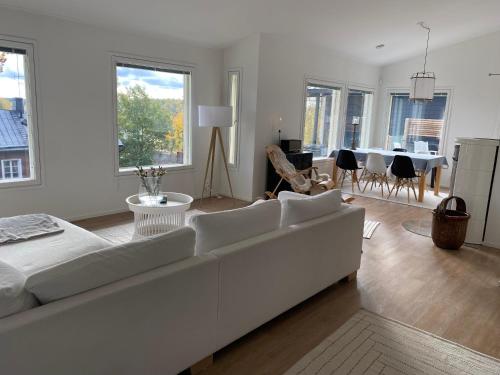 a white living room with a white couch and a dining room at Idyllic sea view house in Porvoo