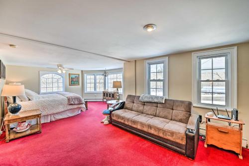 a bedroom with a couch and a bed and windows at All Year-Round Retreat Near Windham Mountain 