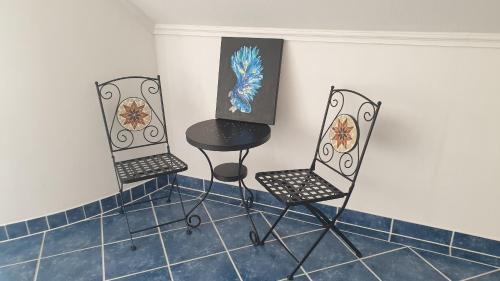 two chairs and a table in a room at Tölgyeserdő Birtok Kaba Szállás és rendezvény in Kaba