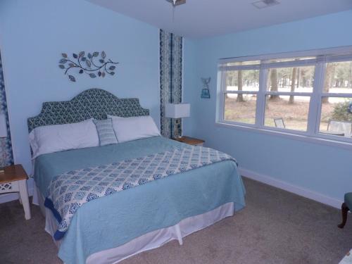 - une chambre bleue avec un lit et 2 fenêtres dans l'établissement Bike & Beach Bungalow at Oyster Bay-Sunset Beach, à Sunset Beach