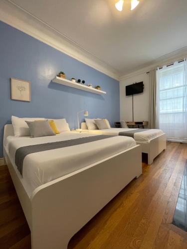 two beds in a bedroom with blue walls at Hotel and the City, Empire State Building in New York