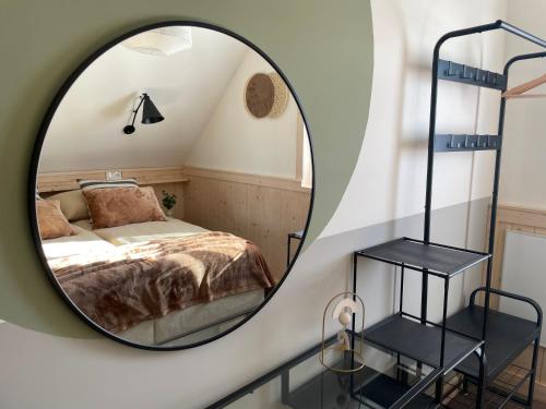 a circular mirror in a bedroom with a bed at Wioska w Sowich Sokolec in Sokolec