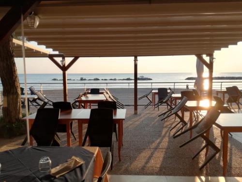 a view of the beach from a restaurant with tables and chairs at Camping La Pineta in Porto Recanati