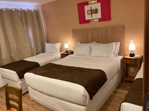 a hotel room with two beds and two lamps at Pousada Renovo da Serra in São Pedro da Serra