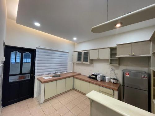 a kitchen with a counter and a sink and a refrigerator at Ipoh 42 Symphony 12pax 4Bedroom 3bathroom 3carpark in Ipoh