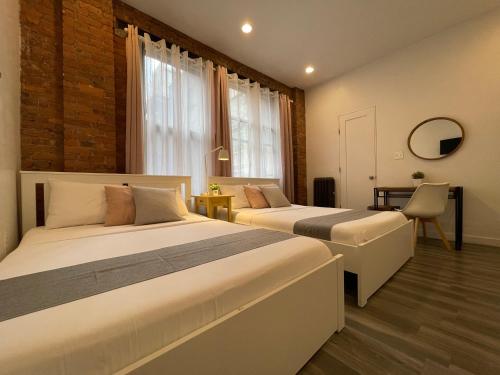 a bedroom with two beds and a chair in it at Hotel and the City, Empire State Building in New York