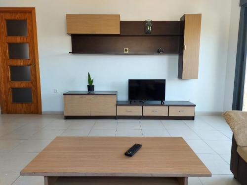sala de estar con TV y mesa de centro en Amplio ático con terraza y aparcamiento entre el mar y desierto - Alborania, en Viator