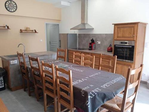 une cuisine avec une table et des chaises ainsi qu'une cuisine avec une cuisinière dans l'établissement Gite A la bonne fermière, à Nevy-sur-Seille