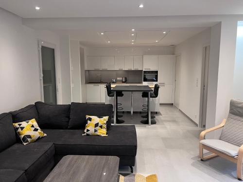 un salon avec un canapé noir et une table dans l'établissement Appartement brest st-marc 6-8personne 2min centre, à Brest