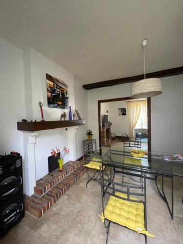 une salle à manger avec une table en verre et une cheminée dans l'établissement Marie Galante, à Sully-sur-Loire