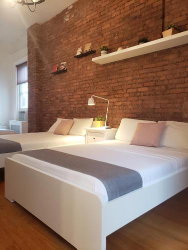 two beds in a room with a brick wall at Hotel and the City, Empire State Building in New York