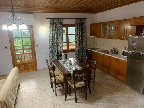 una cucina con tavolo, sedie e frigorifero di Villa Parahora a Prinos