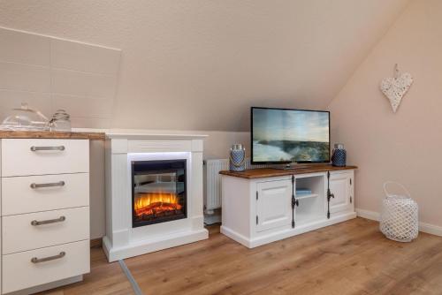 a living room with a fireplace with a tv on top at Seebrise Zingst in Zingst