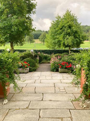 a stone walkway in a garden with flowers and trees at Frühstückspension Herzog zu Laah in Linz