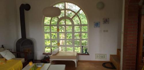 ein Wohnzimmer mit einem großen Fenster und einem Sofa in der Unterkunft Kuća za odmor Voćak in Gornja Voća