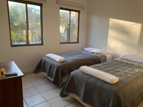 Zimmer mit 2 Betten und 2 Fenstern in der Unterkunft Limpio y confortable depto - Buganvillas 275 in Santa Cruz de la Sierra