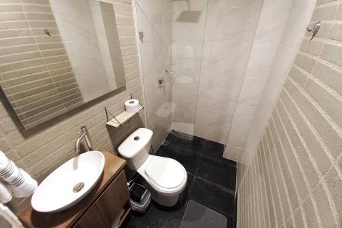 uma casa de banho com um WC branco e um lavatório. em 304 Amazing Loft em Medellín