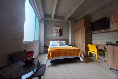 um quarto com uma cama, uma mesa e uma secretária em 304 Amazing Loft em Medellín