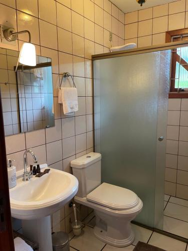 een badkamer met een toilet, een wastafel en een douche bij Jurerê B&B in Florianópolis