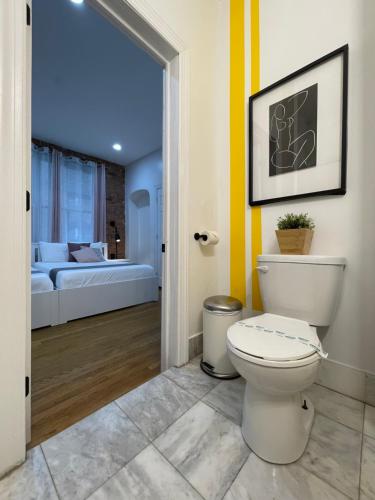 a bathroom with a toilet and a room with a bed at Hotel and the City, Empire State Building in New York