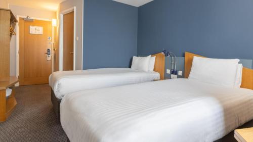 two beds in a hotel room with blue walls at Holiday Inn Express Aberdeen City Centre by IHG in Aberdeen