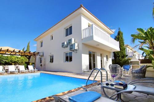 a villa with a swimming pool in front of a house at Nissi Dreams Villa in Ayia Napa